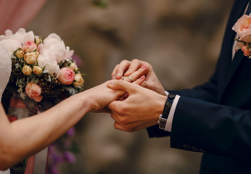 groom putting ring bride s finger