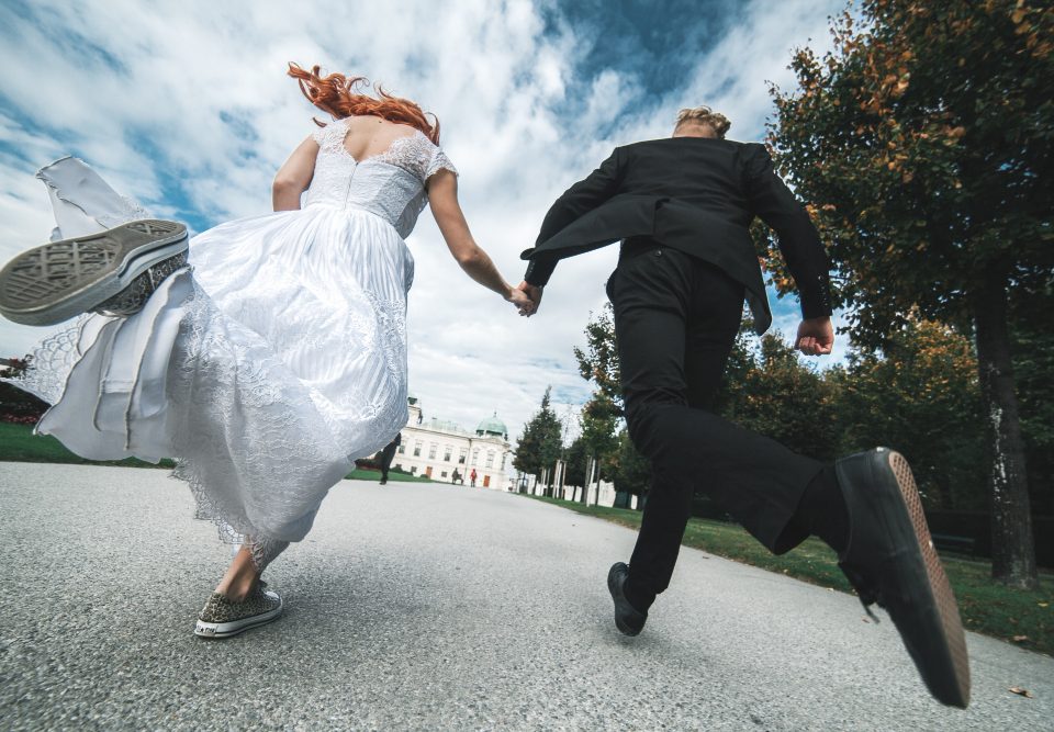 newlyweds running along road