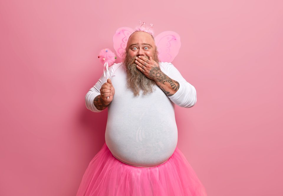 positive bearded male fairy giggles his funny image has amazing capability perform magic wears wings white jumper pleated skirt demonstrates magical power