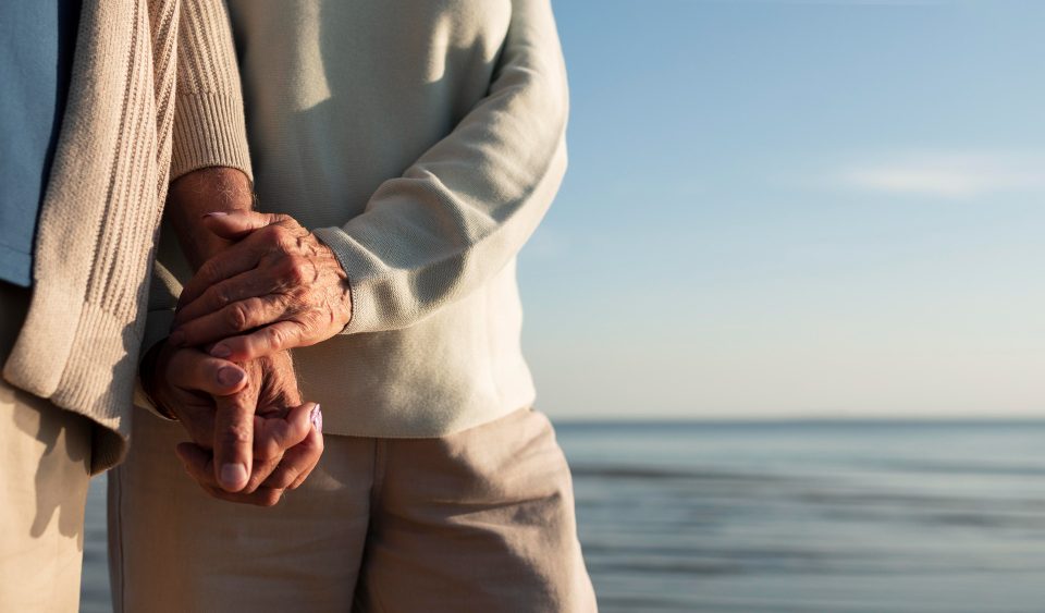 close up partners holding hands seaside
